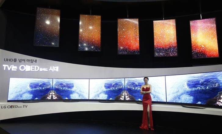 © Reuters. A model poses in front of LG Electronics' flexible OLED TV sets during the 2014 Korea Electronics Show in Goyang