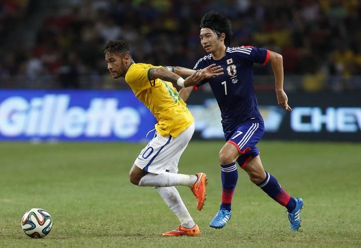 © Reuters. Brazil's Neymar is challenged by Japan's Gaku Shibasaki during their soccer friendly match at the national stadium in Singapore