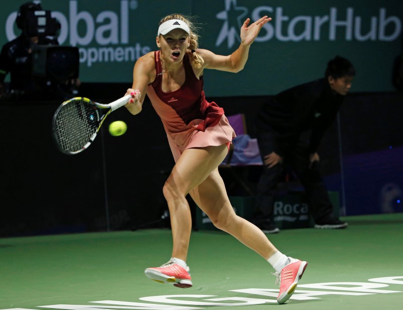 © Reuters. Caroline Wozniacki of Denmark hits a return to Serena Williams of the U.S. during their WTA Finals singles semi-final tennis match at the Singapore Indoor Stadium