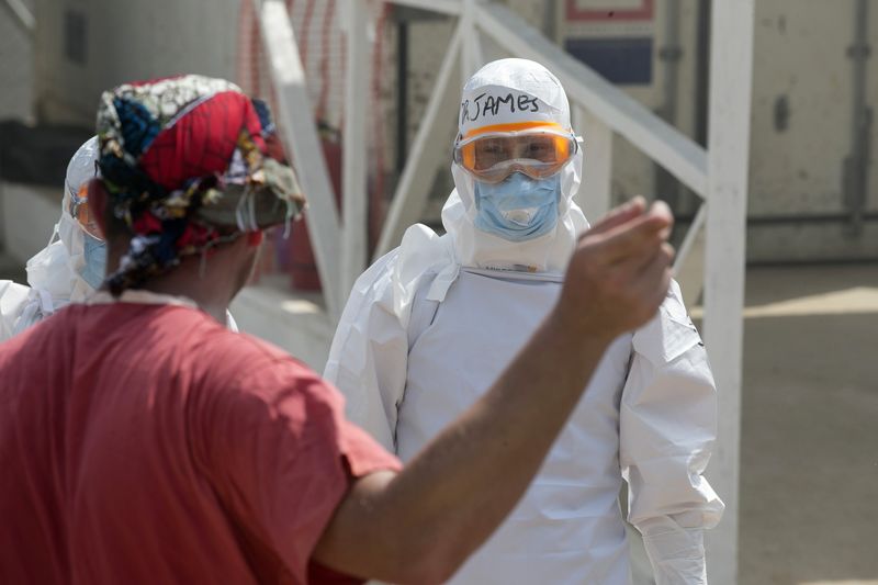© Reuters. Profissional de saúde estrangeiro espera paciente com Ebola em unidade de tratamento da entidade britânica  Save the Children em Freetown, Serra Leoa 
