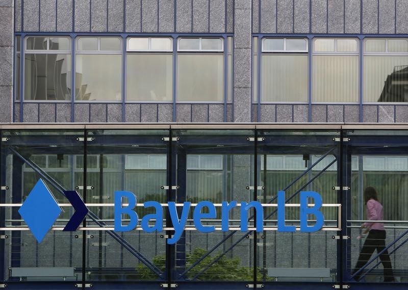 © Reuters. Employee of Bavarian public sector bank BayernLB walks passing bank's logo at BayernLB headquarters in Munich