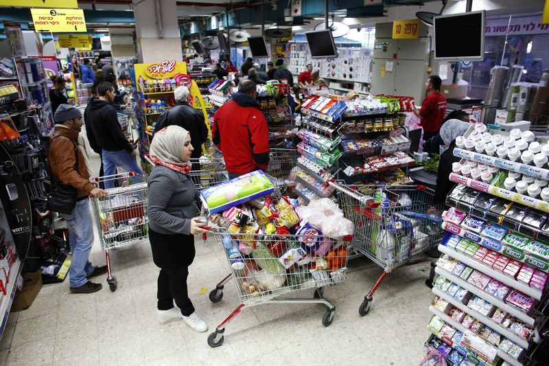 © Reuters. Consumidores compram produtos em mercado de Jerusalém