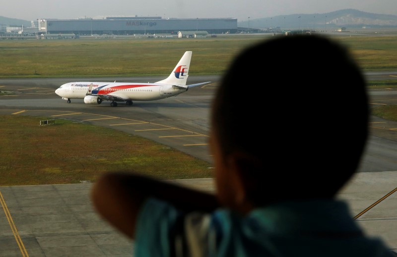 © Reuters. Garoto observa avião da Malaysia Airlines em Kuala Lumpur