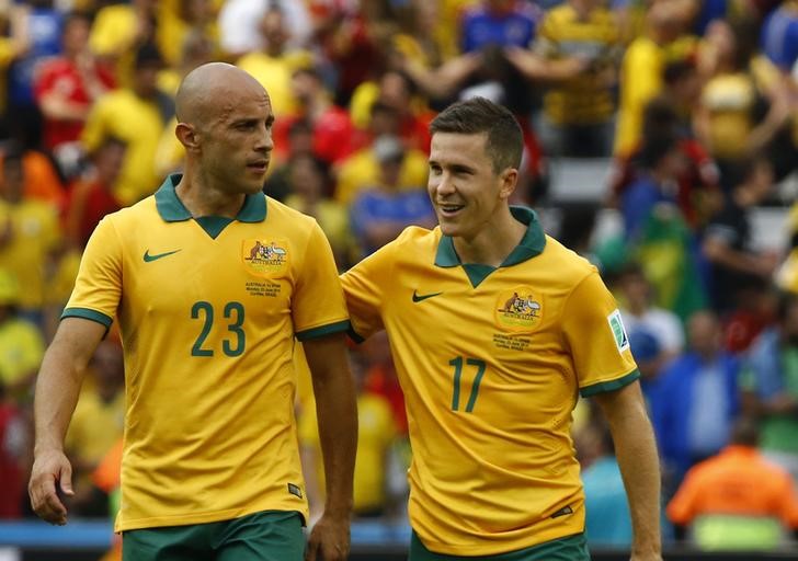 © Reuters. Australia's Mark Bresciano and Matt McKay leave the pitch after their 2014 World Cup Group B soccer match against Spain at the Baixada arena in Curitiba