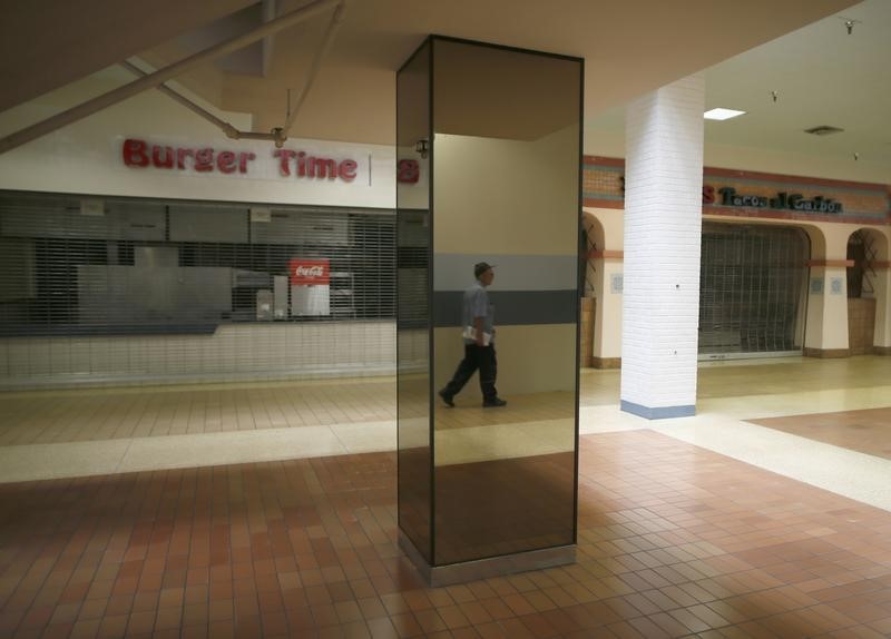 © Reuters. File photo of a man walking past empty stores in the deserted Carousel shopping mall in San Bernardino
