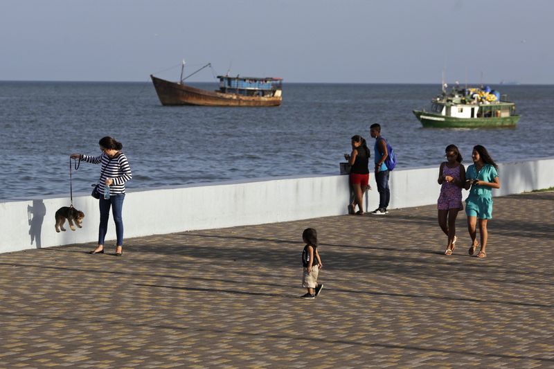 © Reuters. Pessoas caminham em frente ao mar na Cidade do Panamá