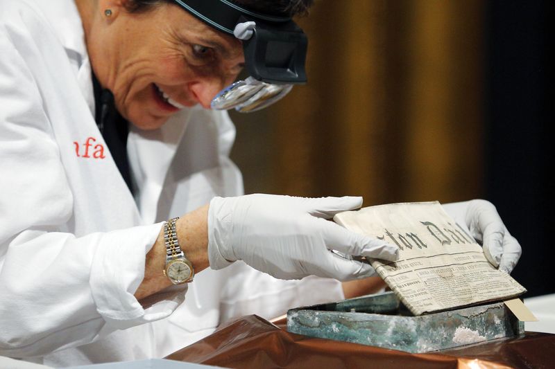 © Reuters. Especialista Pam Hatchfield remove jornal de cápsula do tempo de 220 anos em museu de Boston