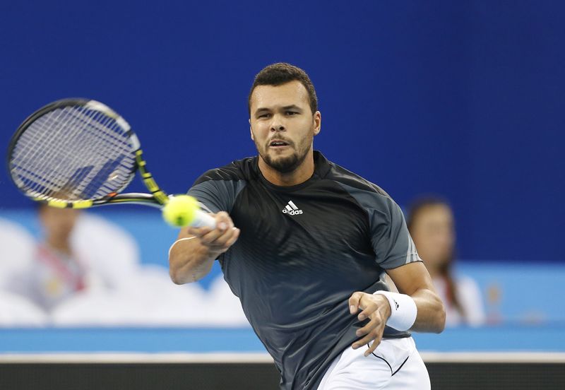 © Reuters. Jo-Wilfried Tsonga his a return to Gael Monfils during their match at the IPTL in Dubai