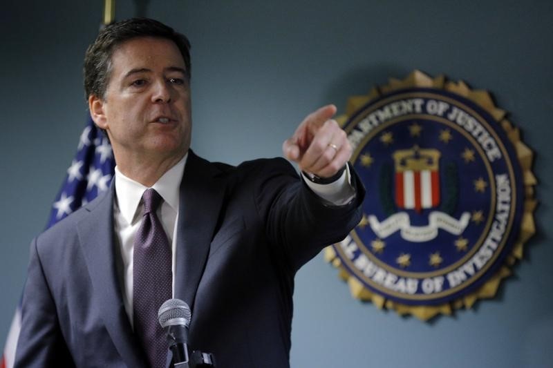 © Reuters. FBI Director James Comey takes a question from reporter during a news conference at the FBI office in Boston