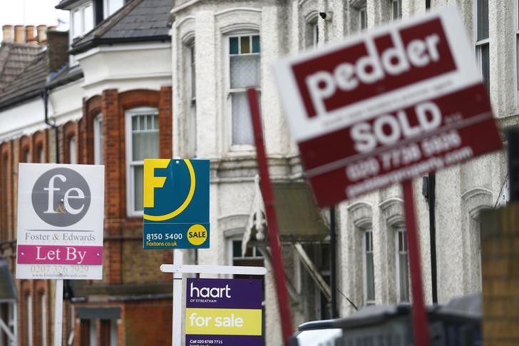 © Reuters. Estate agents boards are lined up outside houses in south London