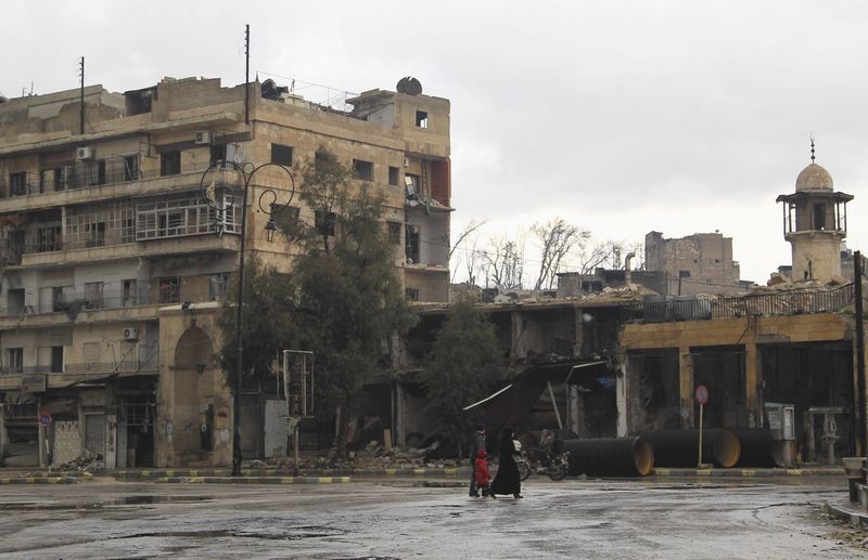 © Reuters. Civilians walk along a deserted street in the old city of Aleppo