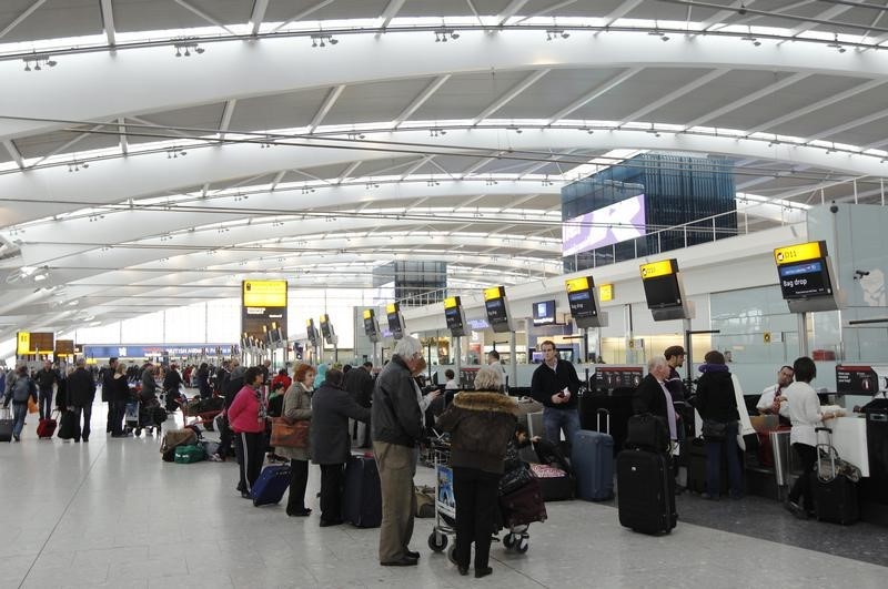 © Reuters. Passengers queue at check-in desks at Terminal 5 at Heathrow airport in London