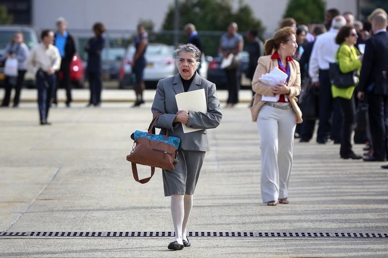 © Reuters. A woman walks to enter a line for the Nassau County Mega Job Fair at Nassau Veterans Memorial Coliseum in Uniondale, New York