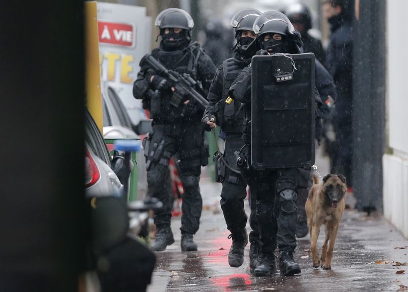 © Reuters. Policiais franceses com um cão farejador em local de tiroteio perto de Paris