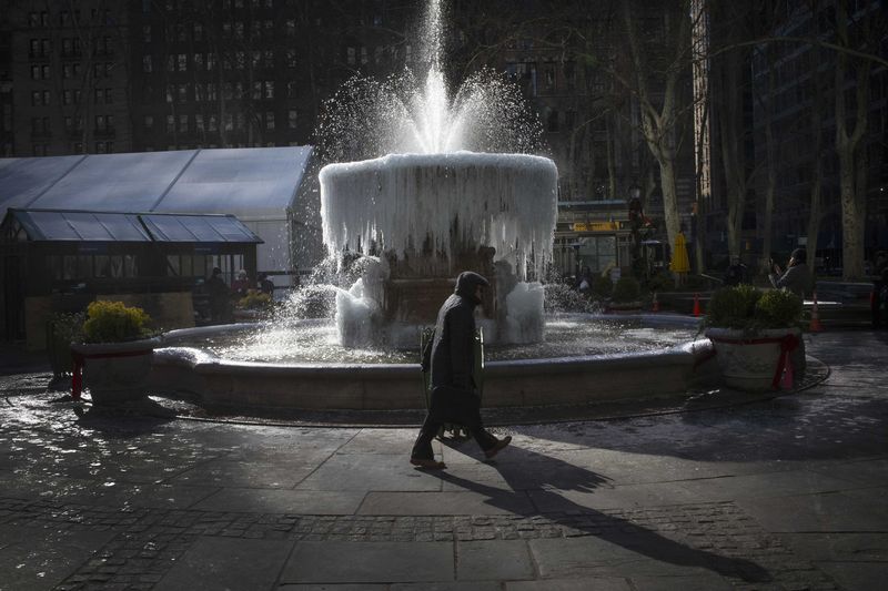 © Reuters. A man walks past the ice-covered Josephine Shaw Lowell Memorial Fountain, in frigid temperatures in Bryant Park in the Manhattan borough of New York City