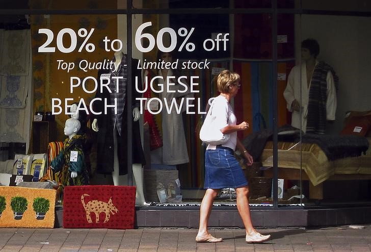 © Reuters. A shopper walks past the window of a store displaying merchandise for sale in Sydney