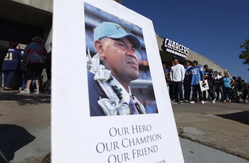 © Reuters. A picture of former San Diego Chargers and NFL linebacker Junior Seau is displayed as fans arrive at Qualcomm Stadium to participate in a "Celebration of Life" memorial, held in his memory in San Diego