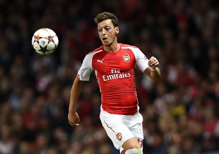 © Reuters. Arsenal's Ozil runs for the ball during their Champions League playoff soccer match against Besiktas at the Emirates stadium in London