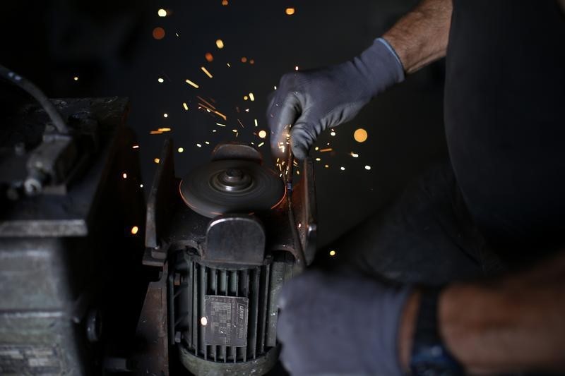 © Reuters. An employee works on a machine in the engine room at the Rivierre plant, the last remaining nails factory in operation in France, in Creil