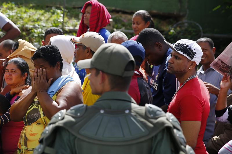 © Reuters. National Guards control access as people line up outside a state-run Bicentenario supermarket in Caracas