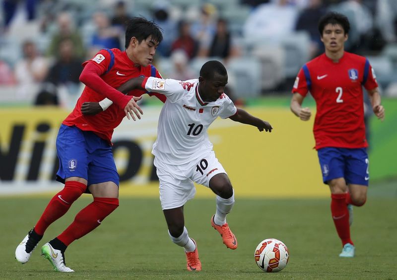 © Reuters. South Korea's Kim Ju-young challenges Oman's Qasim Said as South Korea's Kim Chang-soo looks on during their Asian Cup Group A soccer match at the Canberra stadium in Canberra