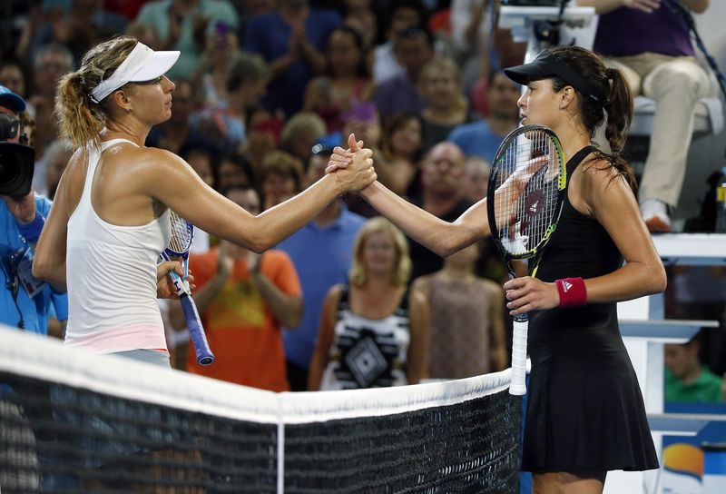 © Reuters. Maria Sharapova of Russia meets Ana Ivanovic of Serbia at the net after Sharapova won their women's singles final match at the Brisbane International tennis tournament in Brisbane