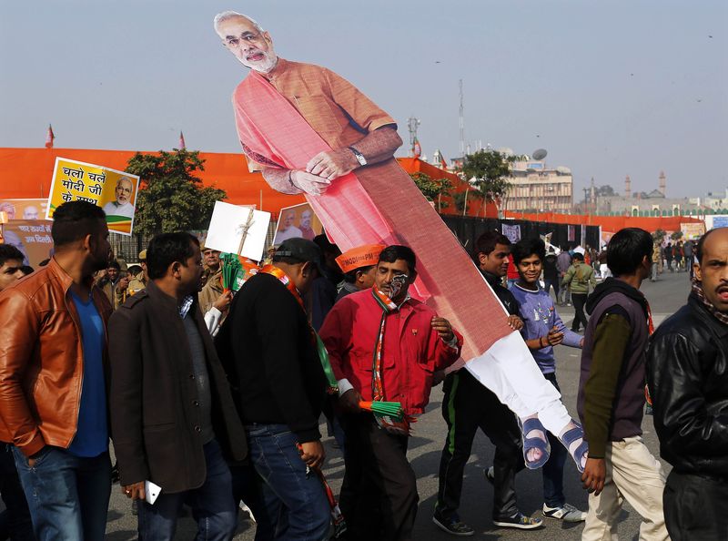 © Reuters. Supporters carry a giant cut-out of Indian PM Modi after attending a campaign rally that was addressed by Modi ahead of state assembly elections  in New Delhi