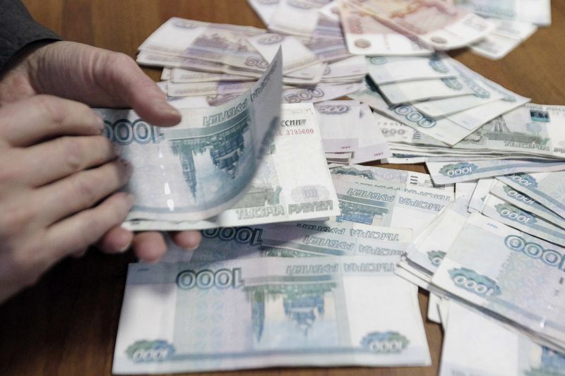 © Reuters. File photo of an employee of a local company counting Russian rouble banknotes in Stavropol