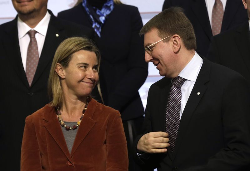 © Reuters. European Union High Representative Mogherini speaks to Latvia's Minister of Foreign Affairs Rinkevics before the family photo at the opening event of Latvia's presidency in European Union in Riga
