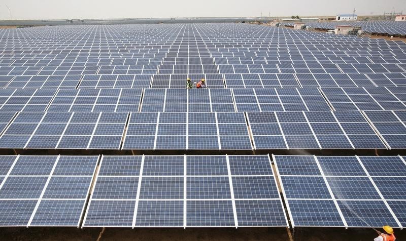 © Reuters. Workers install photovoltaic solar panels at the Gujarat solar park under construction in Charanka village