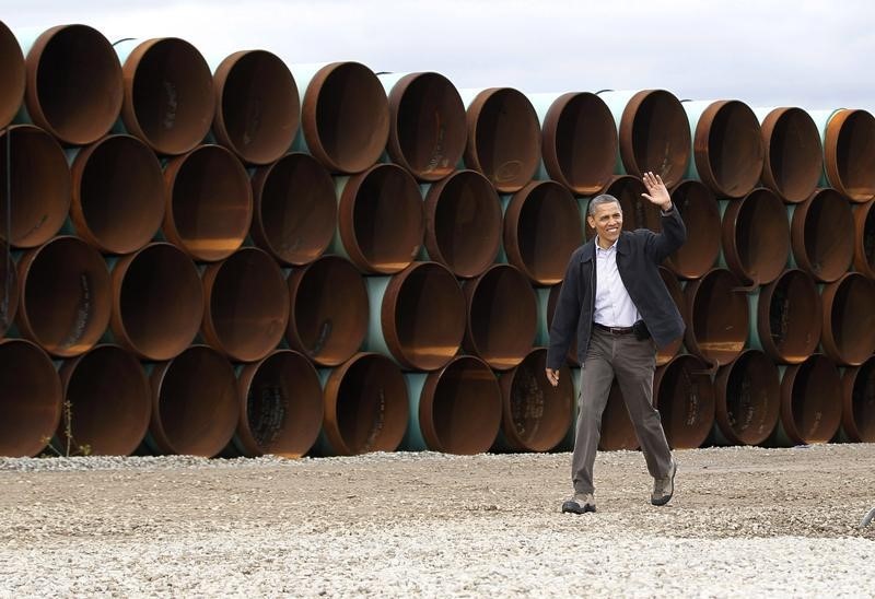 © Reuters. U.S. President Obama walks past oil pipes before delivering remarks on energy independence at Stillwater Pipe Yard in Cushing