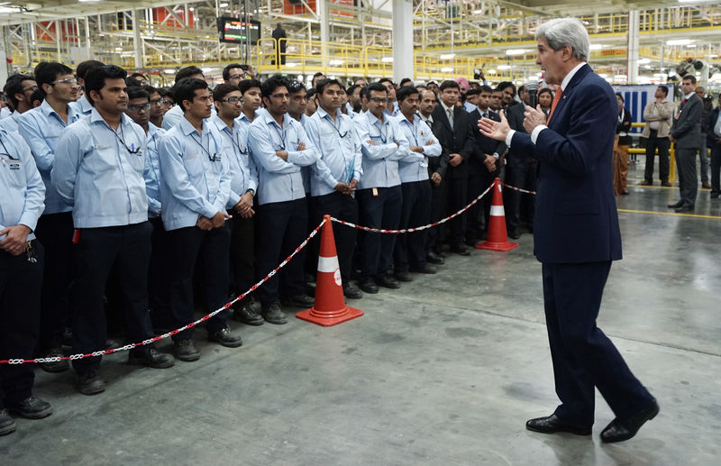 © Reuters. U.S. Secretary of State John Kerry talks to workers at a soon-to-be opened Ford India automotive factory in Sanand