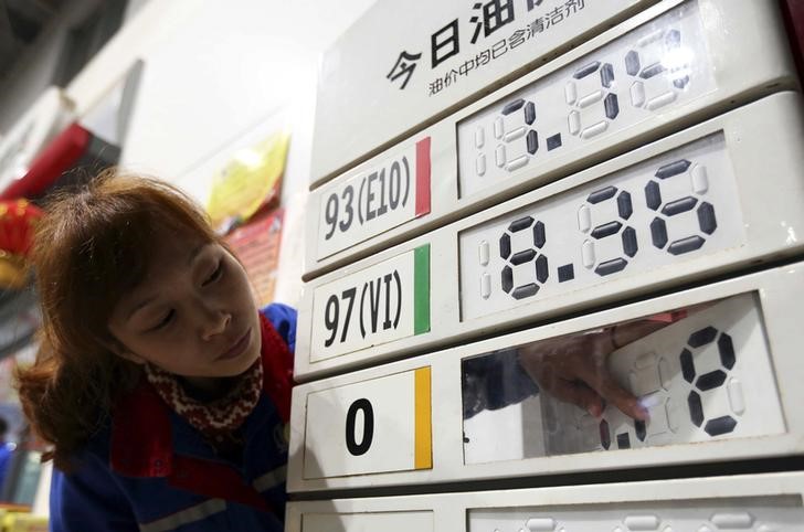 © Reuters. An employee adjusts a diesel price tag on display at a gas station in Rongshui