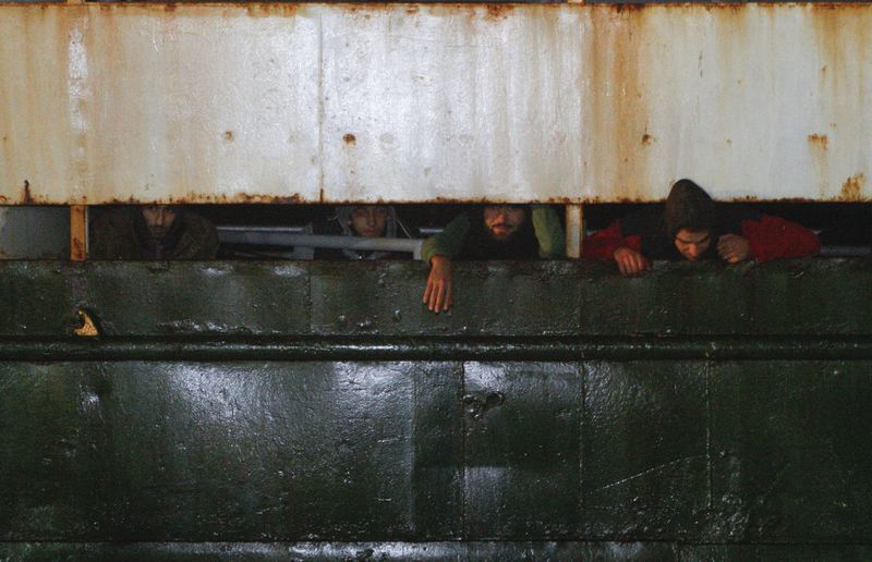 © Reuters. Мигранты на борту судна Ezadeen, прибывающего в Корильяно-Калабро, Италия