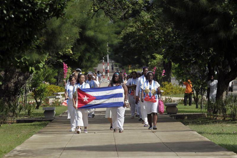 © Reuters. Dissidentes recém-libertadas seguram bandeira cubana durante marcha