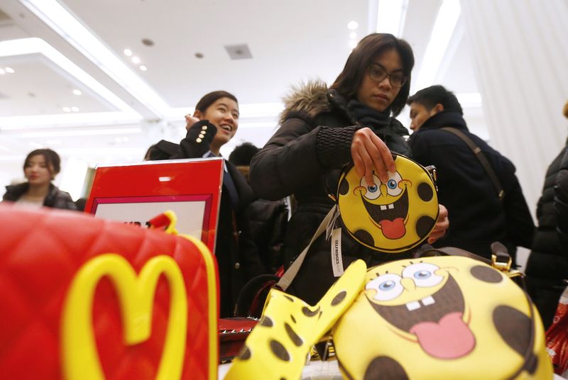 © Reuters. A shopper reaches for a handbag as she hunts for bargains at Selfridges department store on the first day of their sales, in central London