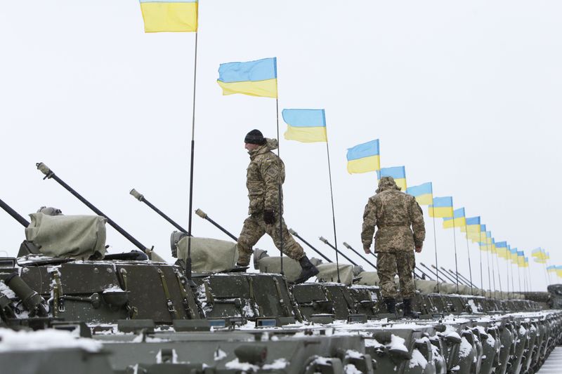 © Reuters. Soldados ucranianos caminham sonre blindados em cerimônia de entrega de equipamentos militares ao Exército em a Zhytomyr