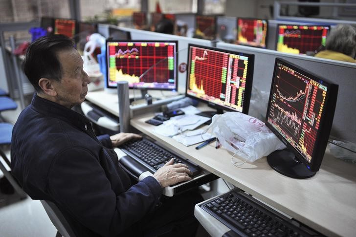 © Reuters. An investor looks at computer screens showing stock information at a brokerage house in Hefei