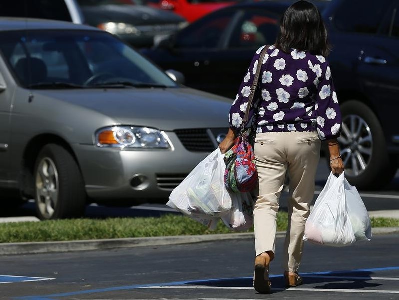 © Reuters. A shopper carries her groceries to her car in plastic bags after shopping at a Sprouts grocery store in San Diego, California