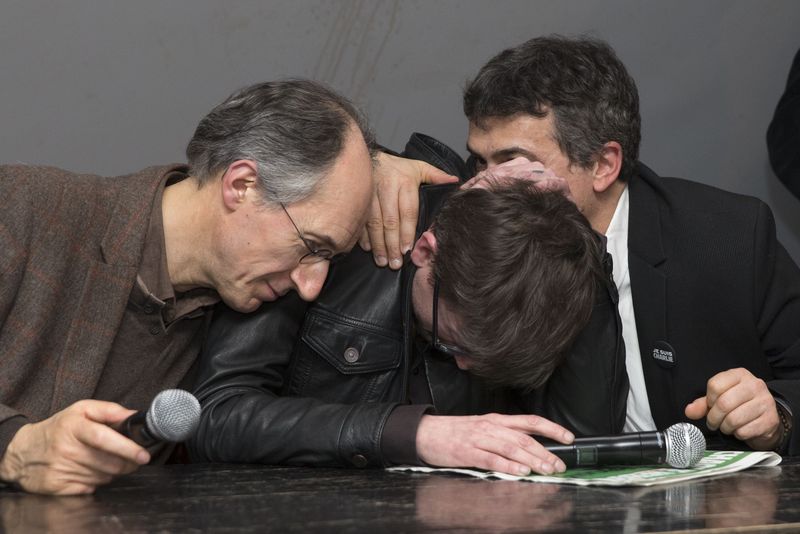 © Reuters. Satirical French magazine Charlie Hebdo new editor in chief Briard and columnist Pelloux comfort cartoonist Luz during a news conference at the French newspaper Liberation offices