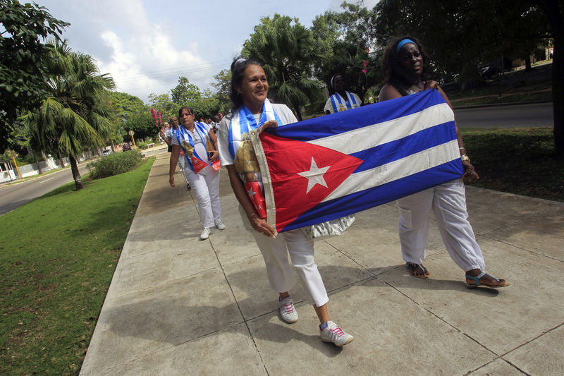 © Reuters. Recently released dissidents Haydee Gallardo and Sonia Garro hold the Cuban national flag during a march in Havana