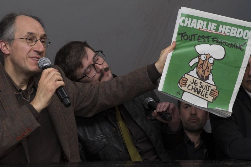 © Reuters. Novo editor-chefe do jornal satírico Charlie Hebdo, Gerard Briard (esquerda) e cartunista Luz mostram capa do jornal durante entrevista coletiva em Paris