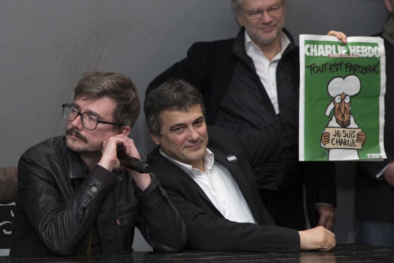 © Reuters. Colunista e cartunista do Charlie Hebdo mostram próxima edição do jornal