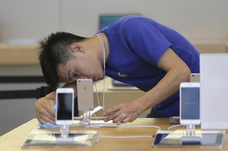 © Reuters. A salesperson cleans next to an iPhone 6 at an Apple store in Beijing