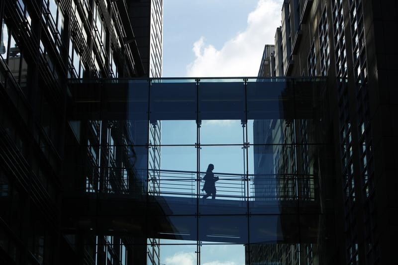© Reuters. A woman crosses a walkway between Goldman Sachs offices in central London