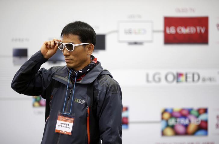 © Reuters. Человек примеряет пару 3D-очков на стенде LG Electronics на выставке Korea Electronics Show в Кояне