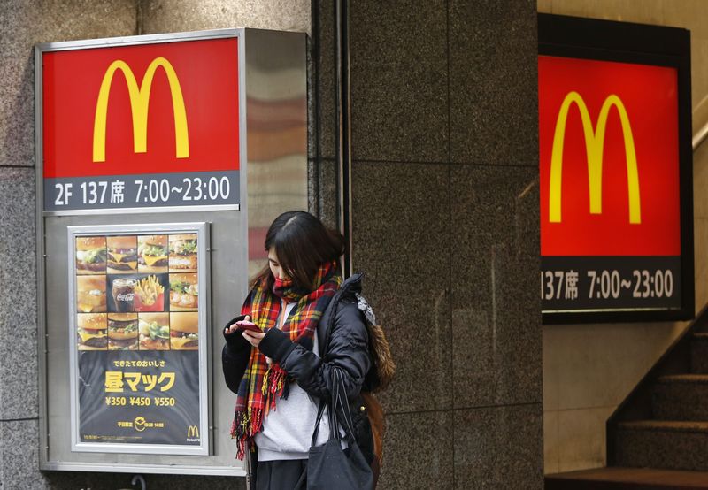 © Reuters. A woman stands in front of a McDonald's store in Tokyo