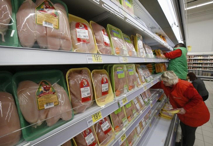 © Reuters. Сотрудники раскладывают продукцию на полках магазина Ашан в Москве