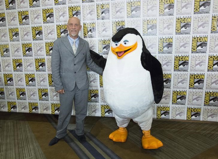 © Reuters. Ator John Malkovich, que faz a voz de Dave  no filme "Pinguins de Madagascar", acompanhado de Skipper em San Diego