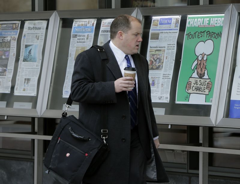 © Reuters. Homem observa capa da última edição do jornal francês Charlie Hebdo ao lado de jornais norte-americanos no museu Newseum em Washington